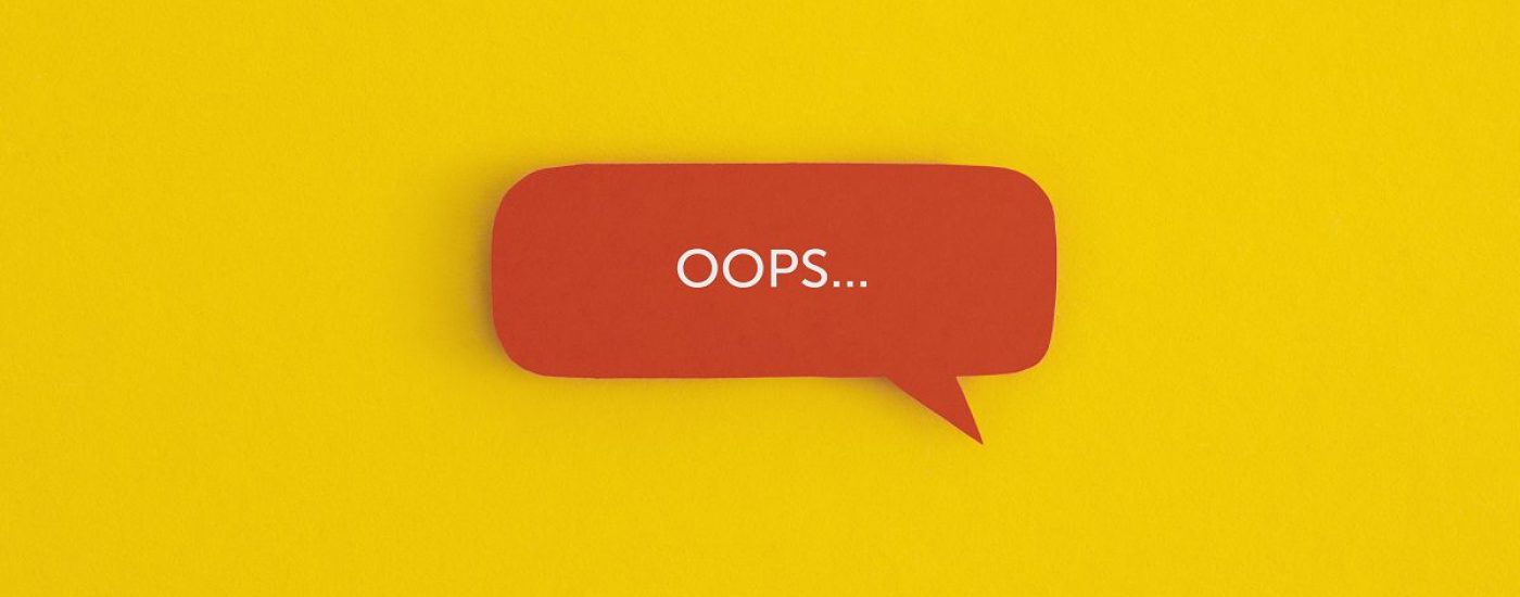 Paper speech bubble with the word "OOPS" on a yellow background. Top view with copy space. Flat lay.